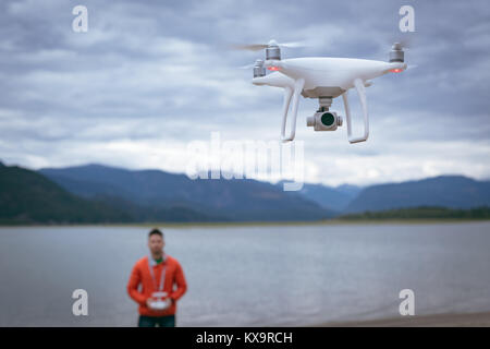 Man operating drone flying by remote control Stock Photo
