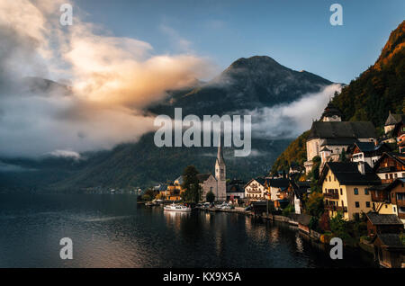Scenic view of famous Hallstatt lakeside town reflecting in Hallstattersee lake in the Austrian Alps in morning light with bright clouds, Salzkammergu Stock Photo