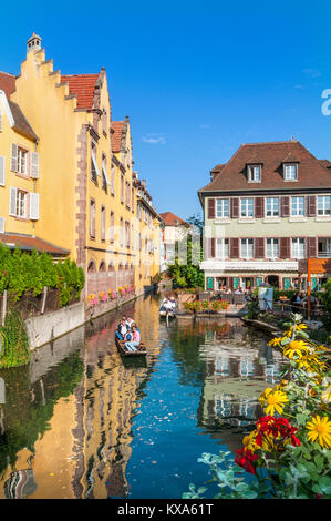 COLMAR LITTLE VENICE FLOWERS canal boat trip cruise visitors exploring waterway in 'Petite Venise' on clear sunny summer day Colmar Alsace France Stock Photo