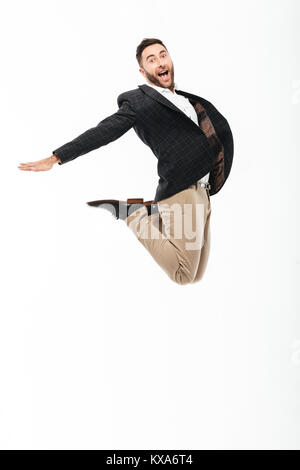 Full length portrait of an excited cheerful man celebrating success while jumping isolated over white background Stock Photo