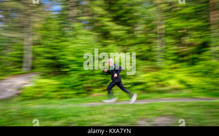 Elderly man jogging in a forest Stock Photo