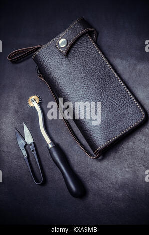 working tools, leather wallet on black background, top view. Stock Photo