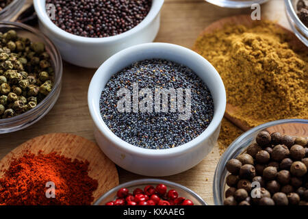 Poppy seeds and other spices on a wooden surface Stock Photo