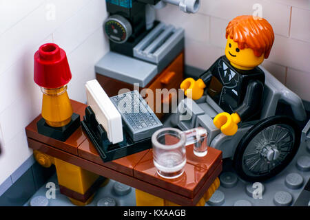 Tambov, Russian Federation - October 18, 2017 Lego office worker in wheelchair on his workplace. Studio shot. Stock Photo