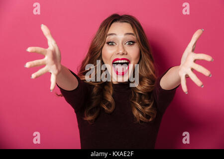 Photo of young surprised beautiful woman standing isolated over pink background. Looking camera. Stock Photo