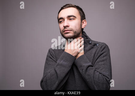 Young man having sore throat and touching his neck against light grey background. Hard to swallow Stock Photo