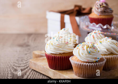 Delicious birthday cupcakes on wooden table Stock Photo