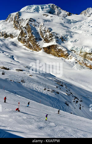 Skiers on the Längfluh ski slope in front of the snow-covered Alphubel,Saas-Fee,Valais,Switzerland Stock Photo