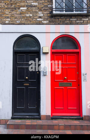 Black door next to a red door in the front facade of a Victorian British English house Stock Photo