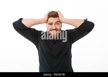 Worried bearded man in shirt holding his head and looking at the camera over white background Stock Photo