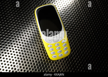 Yellow phone on metal surface Stock Photo