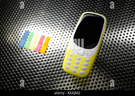 Yellow phone on metal surface Stock Photo