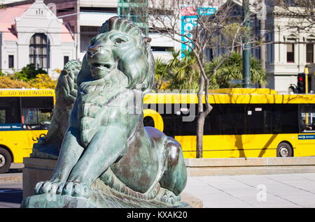 Wellington, New Zealand - 28 September, 2015: Bronze Lions at the base of the Wellington Cenotaph with city buses in the background, located  on the i Stock Photo