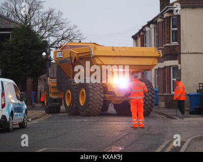 Sheerness, Kent, UK. 8th Jan, 2018. The unusual sight of a giant dumper truck being unloaded, briefly blocking Marine Parade in Sheerness. The Bell articulated dump truck is being used for sea defense work being undertaken by the Environment Agency to move large volumes of shingle. Credit: James Bell/Alamy Live News Stock Photo