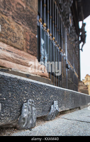 Two mysterious metal hands come out of a crack of a curb of the cathedral of St. Bartholomew in Pilsen, Czech Republic, on January 8, 2018. Officially, nobody knows who gave it into a crack about the end of the last year, or whether it have any meaning. (CTK Photo/Miroslav Chaloupka) Stock Photo