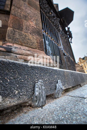 Two mysterious metal hands come out of a crack of a curb of the cathedral of St. Bartholomew in Pilsen, Czech Republic, on January 8, 2018. Officially, nobody knows who gave it into a crack about the end of the last year, or whether it have any meaning. (CTK Photo/Miroslav Chaloupka) Stock Photo