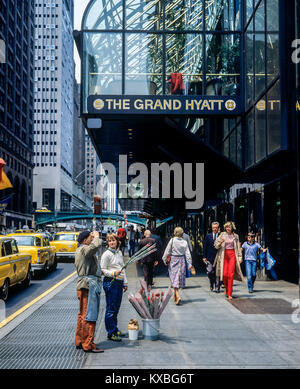 New York 1980s, flower seller chatting wth a man, people, The Grand Hyatt hotel, East 42nd street, Manhattan, New York City, NY, NYC, USA, Stock Photo