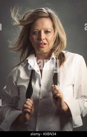 Mature woman wearing a white shirt and black bow tie Stock Photo