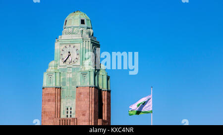 FINLAND, HELSINKI, JUL 02 2017, Clock tower of Helsinki central railway station with flying flag of VR Group, government-owned railway company. Stock Photo