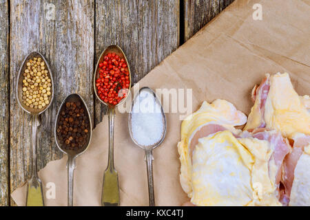 Cooking chicken. The table with the ingredients for the dishes. On a wood background. raw chicken meat with herbs and spices Stock Photo