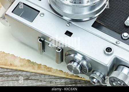 vintage camera and old photos on wooden background macro view Stock Photo