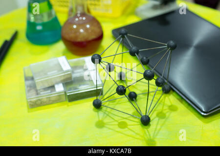 chemical composition, science, study concept. on the table in chemical class there are different multicolored glass vessels, black laptop for creating Stock Photo