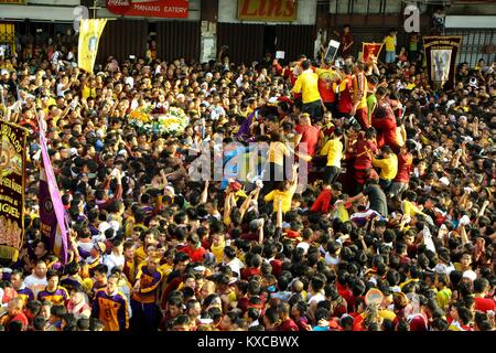 Manila, Philippines. 09th Jan, 2018. Devotees wave on the translacion of the Black Nazarene statue while passing under the Quezon Bridges in Palanca street. Devotees trying to touch the icon of Black Nazarene and the rope as their belief that it may granted their wish or part of their “Panata” or devotions. Credit: Gregorio B. Dantes Jr./Pacific Press/Alamy Live News Stock Photo