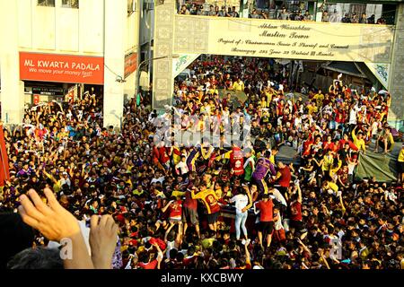 Manila, Philippines. 09th Jan, 2018. Devotees wave on the translacion of the Black Nazarene statue while passing under the Quezon Bridges in Palanca street. Devotees trying to touch the icon of Black Nazarene and the rope as their belief that it may granted their wish or part of their “Panata” or devotions. Credit: Gregorio B. Dantes Jr./Pacific Press/Alamy Live News Stock Photo