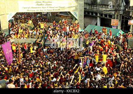 Manila, Philippines. 09th Jan, 2018. Devotees wave on the translacion of the Black Nazarene statue while passing under the Quezon Bridges in Palanca street. Devotees trying to touch the icon of Black Nazarene and the rope as their belief that it may granted their wish or part of their “Panata” or devotions. Credit: Gregorio B. Dantes Jr./Pacific Press/Alamy Live News Stock Photo