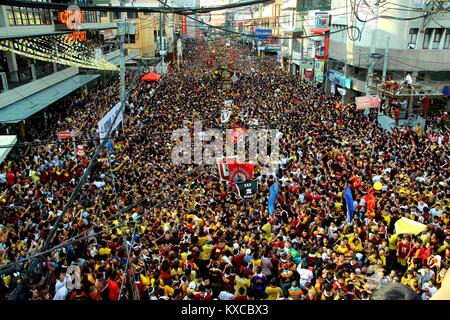 Manila, Philippines. 09th Jan, 2018. Devotees wave on the translacion of the Black Nazarene statue while passing under the Quezon Bridges in Palanca street. Devotees trying to touch the icon of Black Nazarene and the rope as their belief that it may granted their wish or part of their “Panata” or devotions. Credit: Gregorio B. Dantes Jr./Pacific Press/Alamy Live News Stock Photo