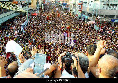 Manila, Philippines. 09th Jan, 2018. Devotees wave on the translacion of the Black Nazarene statue while passing under the Quezon Bridges in Palanca street. Devotees trying to touch the icon of Black Nazarene and the rope as their belief that it may granted their wish or part of their “Panata” or devotions. Credit: Gregorio B. Dantes Jr./Pacific Press/Alamy Live News Stock Photo