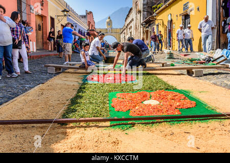 Antigua, Guatemala -  March 25, 2016: Locals make dyed sawdust Good Friday procession carpets in town with famous Holy Week celebrations Stock Photo