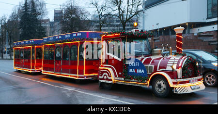 VILNIUS, LITHUANIA - DECEMBER 30, 2017:  Christmas illuminated trains ride with children through the streets of the New Year European city. Stock Photo