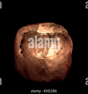 Salt lamp made with pink Himalayan salt, isolated on black background Stock Photo