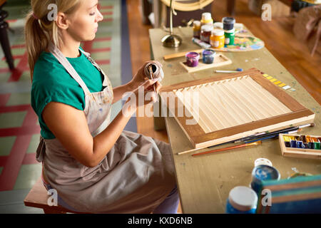 Young Female Artist Working in Studio Stock Photo
