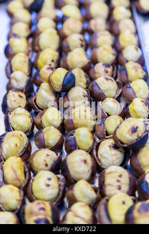 Many Grilled,roasted chestnuts for sale on a stall Stock Photo