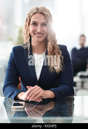 Portrait of attractive business woman sitting in modern office. Stock Photo