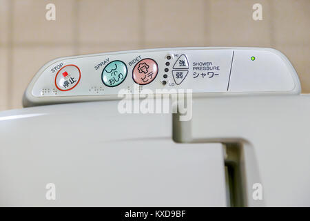 Osaka, Japan - October 29 2014: Western style toilets in Japan feature a heated seat, a built-in shower with brailler letters on the panel for the bli Stock Photo