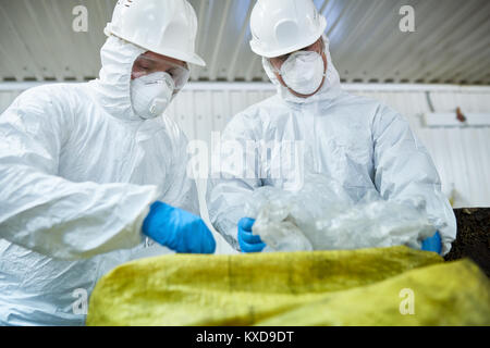 Workers Sorting Trash on Conveyor Belt Stock Photo