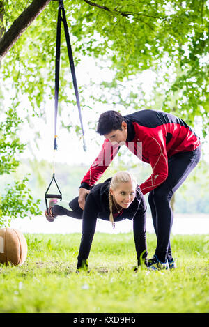 Man and woman at fitness training doing push-ups Stock Photo