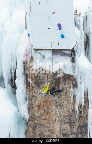 Male ice climber clinging horizontally to rocks on competition route, Ouray Ice Park, Colorado, USA Stock Photo