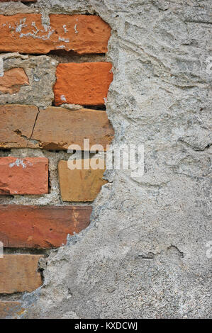 Red bricks stone wall background closeup, cracked ruined stucco, vertical plastered grunge grey beige stonewall limestone pattern, old aged weathered  Stock Photo