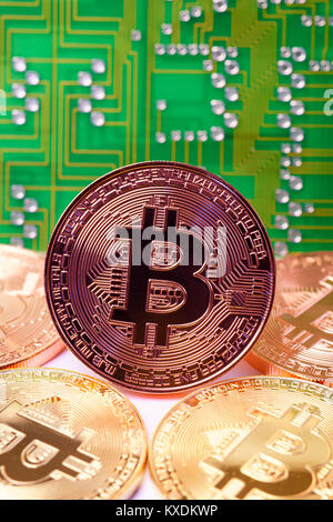 Symbol image of digital currency, physical coins Bitcoin in front of printed circuit board Stock Photo
