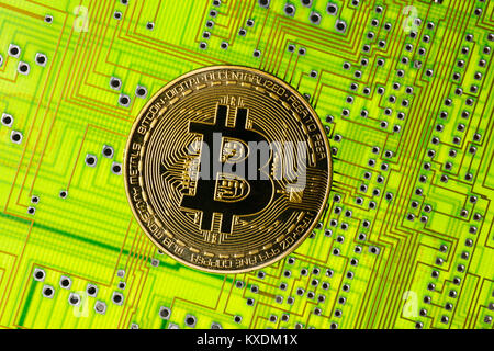 Symbol image digital currency, gold physical coin Bitcoin with printed circuit board Stock Photo