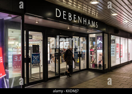 Debenhams shop front entrance open after dark in Worthing, West Sussex, England, UK. Retail store. Stock Photo