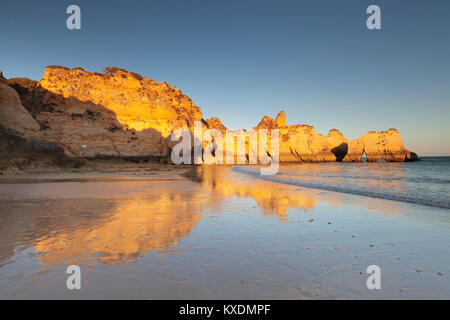 Sandstone cliffs on the beach Praia de tres Irmaos at sunset, Alvor, Algarve, Portugal Stock Photo