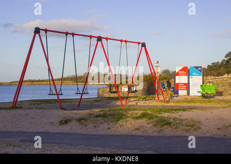 The small children's playground  with swings and see saws at The Banks in the Ballyholme area of Bangor County Down on a winter day. Stock Photo