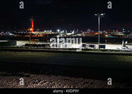 Night view of the operations mess and delays at the John F. Kennedy International Airport (JFK) after the bomb cyclone winter snow storm Grayson. Stock Photo