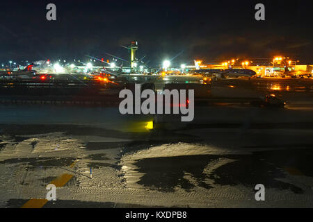 Night view of the operations mess and delays at the John F. Kennedy International Airport (JFK) after the bomb cyclone winter snow storm Grayson. Stock Photo