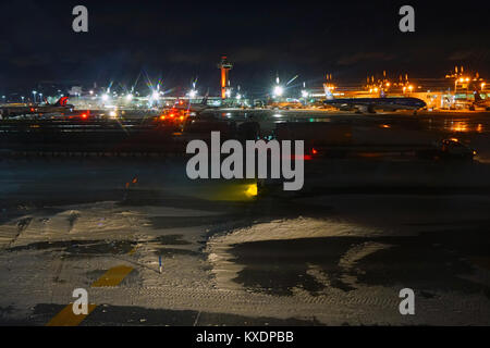 Night view of the operations mess and delays at the John F. Kennedy International Airport (JFK) after the bomb cyclone winter snow storm Grayson. Stock Photo